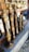 Several intricately designed musical instruments with ornate golden and bronze detailing are arranged on a stone shelf. Behind the instruments, there are reflections and glimpses of other metallic items, possibly more instruments or decorative objects.