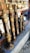 Several intricately designed musical instruments with ornate golden and bronze detailing are arranged on a stone shelf. Behind the instruments, there are reflections and glimpses of other metallic items, possibly more instruments or decorative objects.