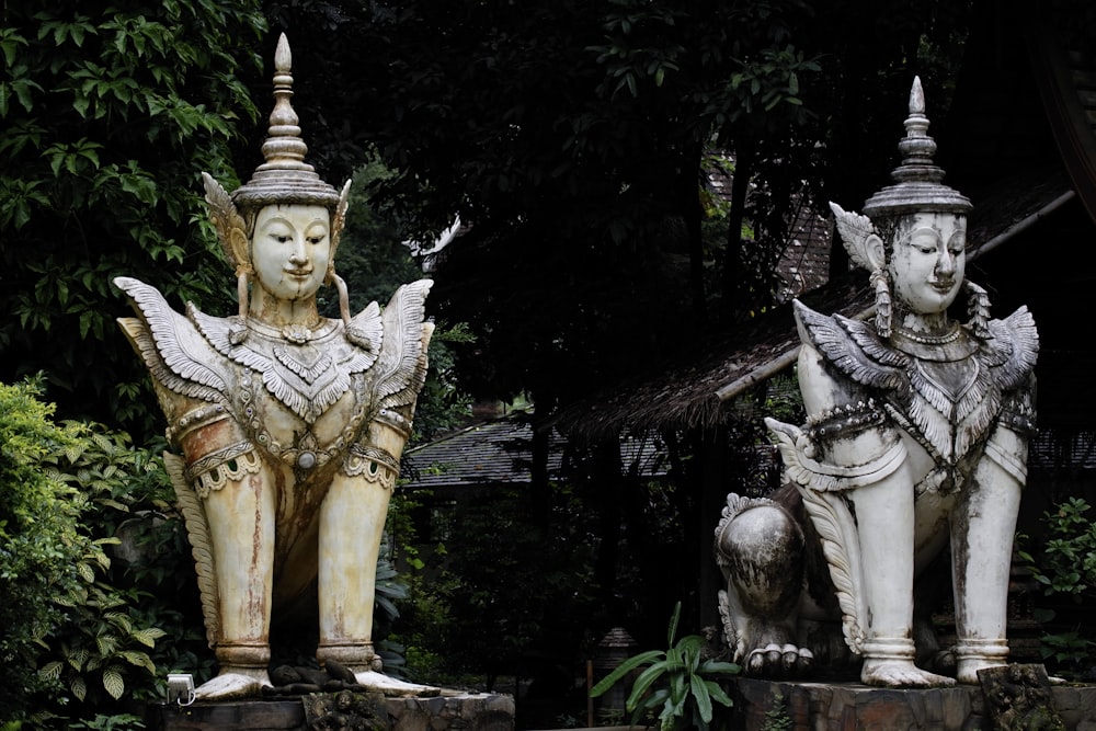 deux statues de tête d’homme près d’arbres