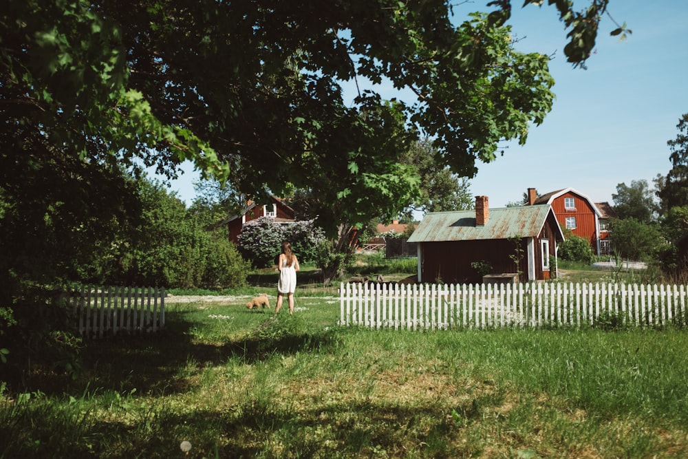 woman standing beside dog in green lawn