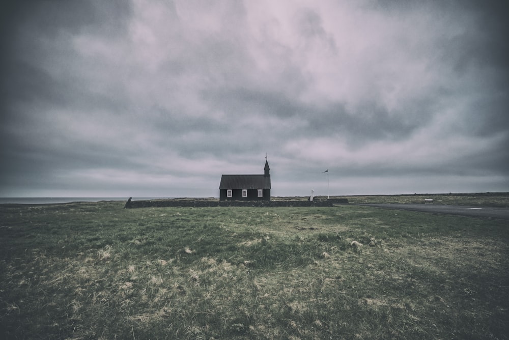 black concrete house at middle of field