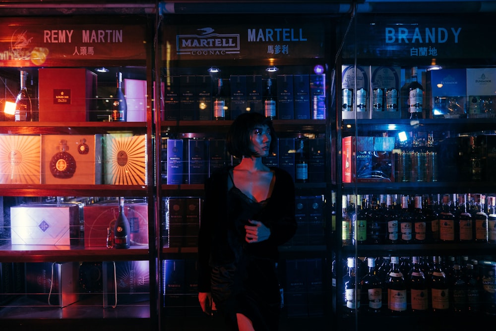 femme debout à côté d’un magasin d’alcool