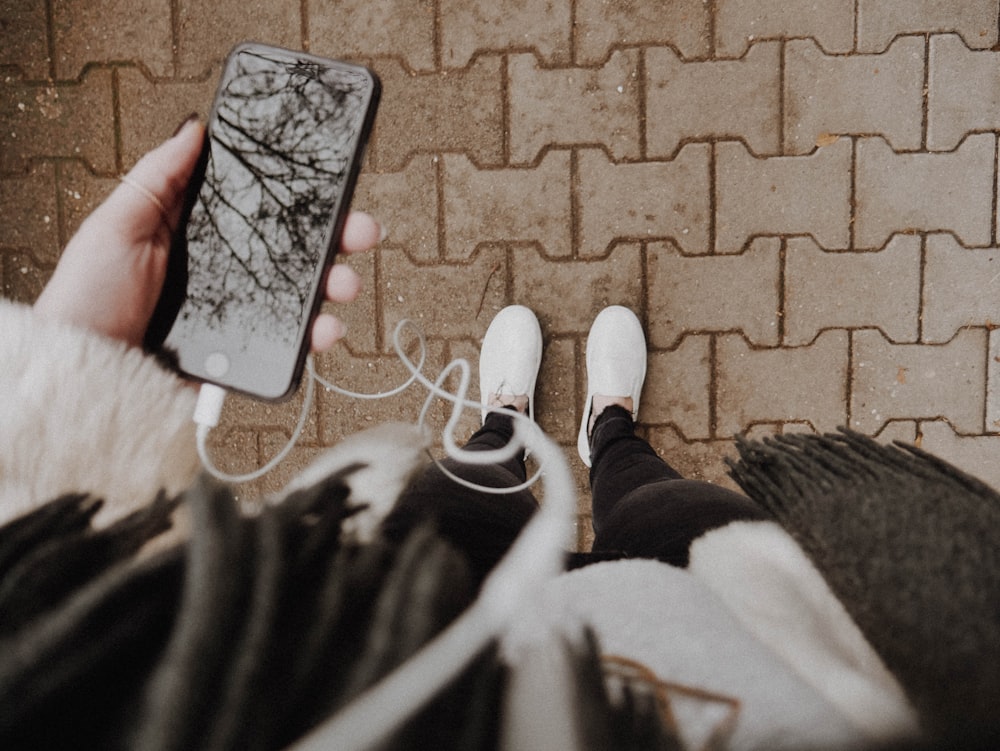 Persona in piedi mentre tiene il telefono