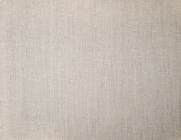 Close-up of breathable linen fabric showing its natural texture and airy weave in soft beige tones.