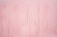 A soft, pink background with vertical brushstrokes creating a subtle texture.