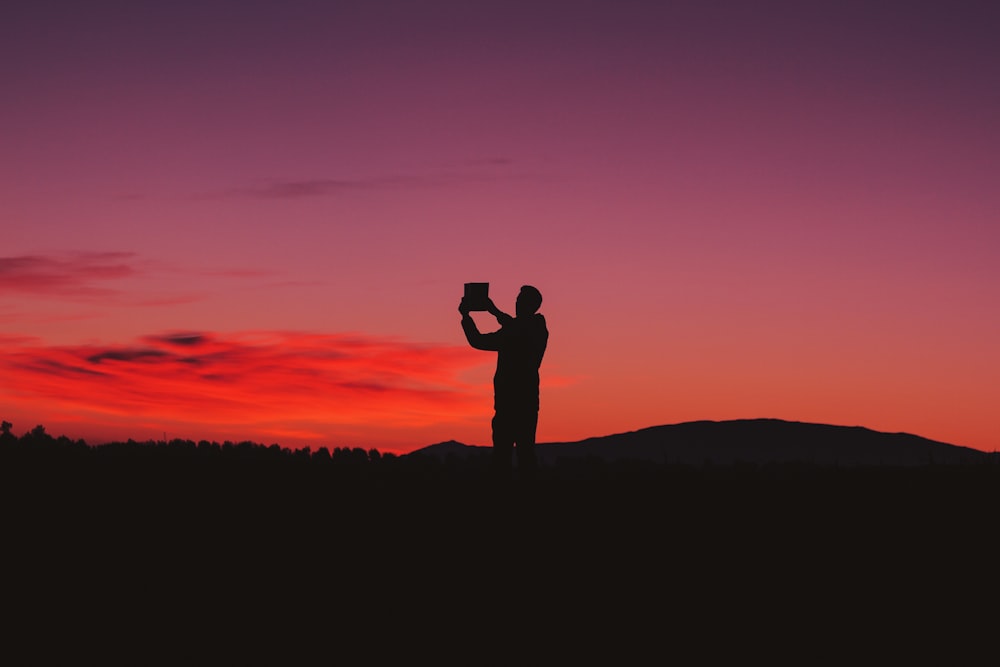 silhouette photo of man on hill