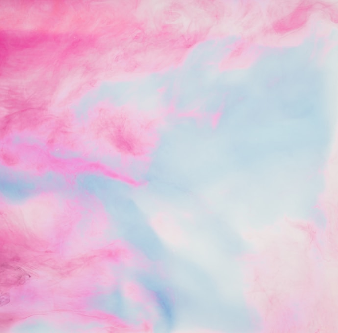a pink and blue background with clouds in the sky