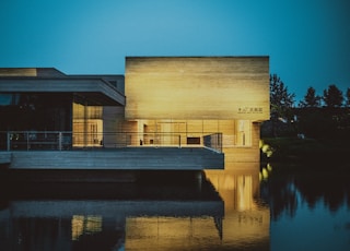 brown building beside body of water at nighttime