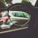 A pair of eyeglasses held up to a car window, focusing on the car outside. The lens frames the vehicle, highlighting the contrast between the lens-focused sharpness and the blurred surroundings.