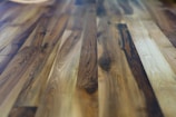 Rich and polished hardwood floor with a variety of brown hues and natural wood grain patterns, giving a warm and cozy appearance.