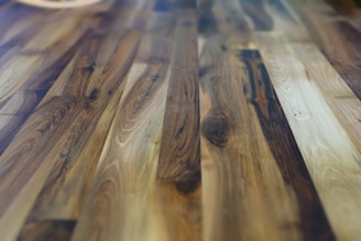 Rich and polished hardwood floor with a variety of brown hues and natural wood grain patterns, giving a warm and cozy appearance.