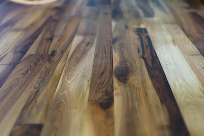 Rich and polished hardwood floor with a variety of brown hues and natural wood grain patterns, giving a warm and cozy appearance.