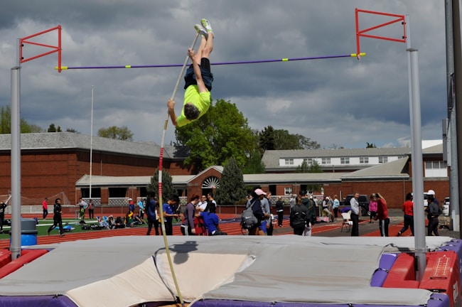A young athlete vaulting over a bar in the covered parkour training area at Parkour Shard.
