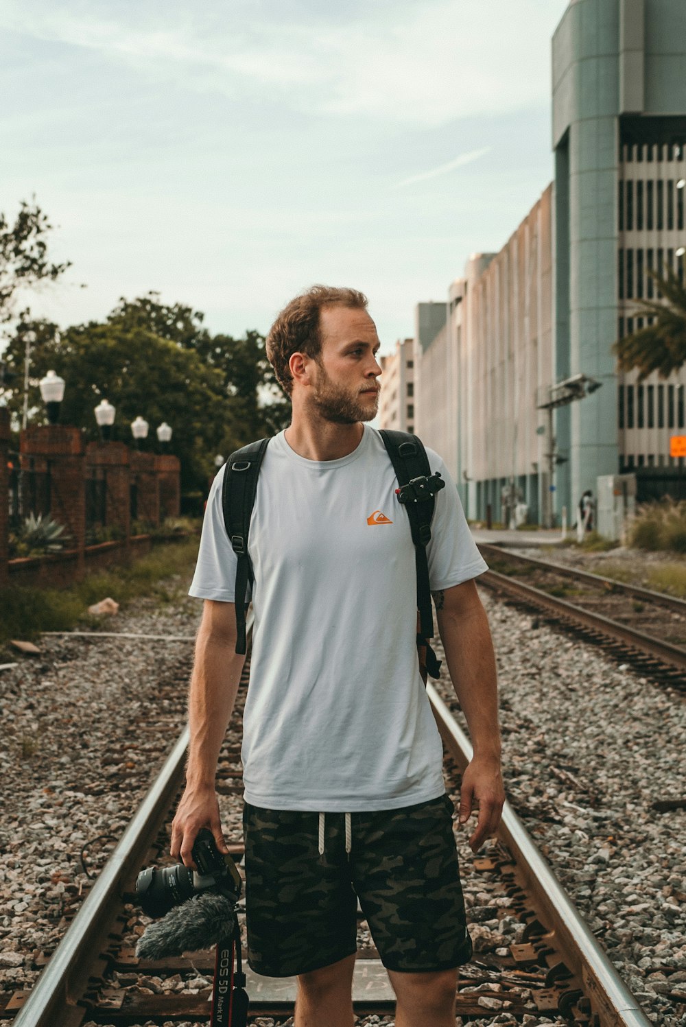 man standing on train rail at daytime