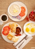 A rustic wooden table set with a breakfast spread featuring country biscuits and sausage gravy.