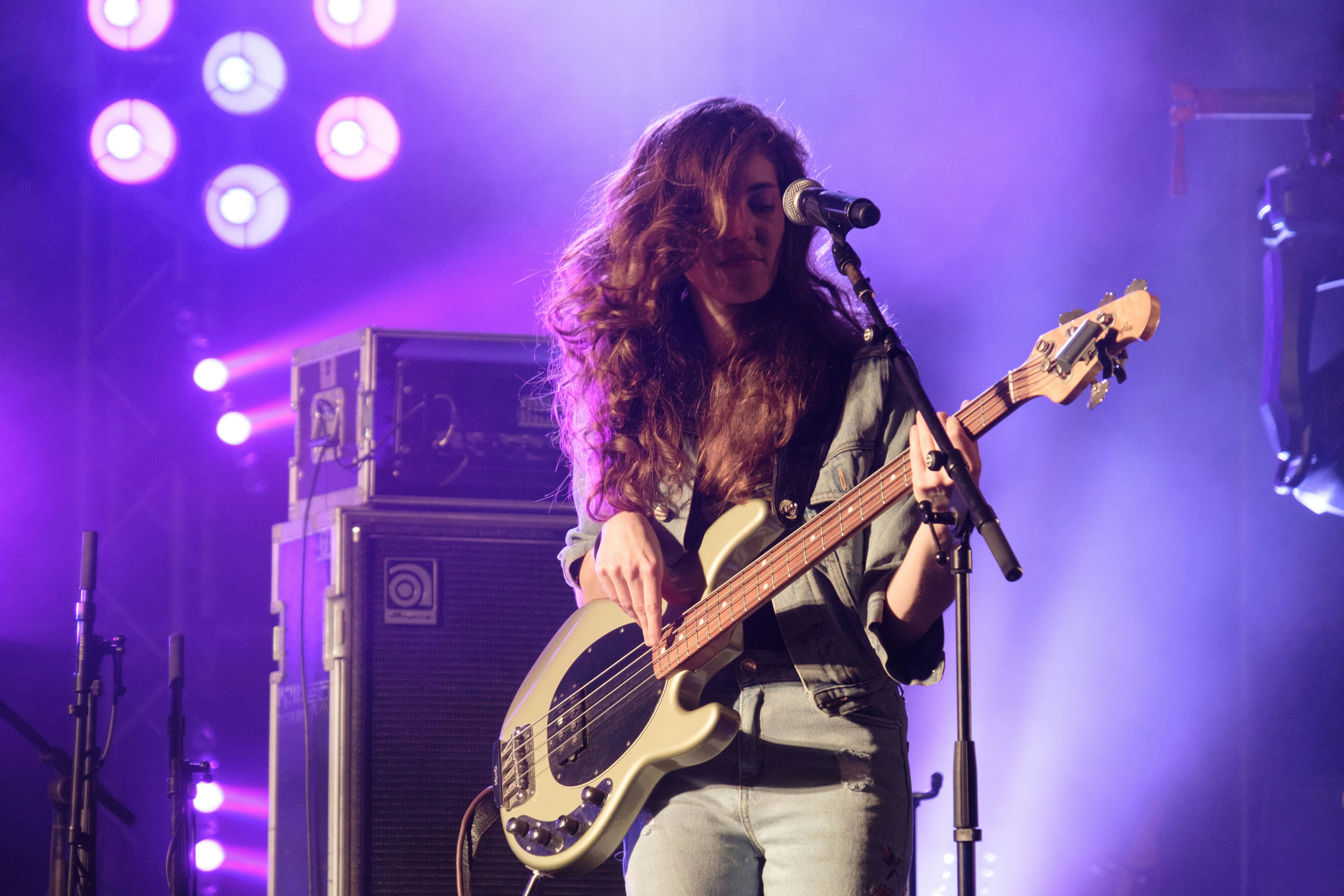 feminist musician playing bass guitar on music festival or concert