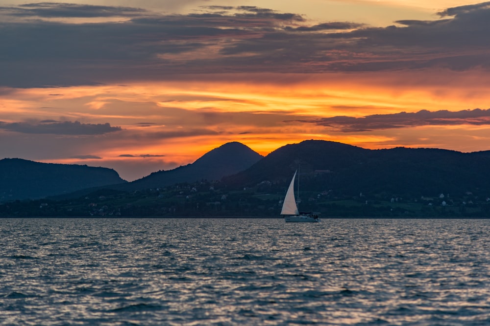 white sailboat traveling on a body of water