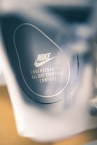 Close-up view of a shoe insole featuring the Nike logo and the text 'Engineered for all day everyday comfort' printed in white against a gray background.