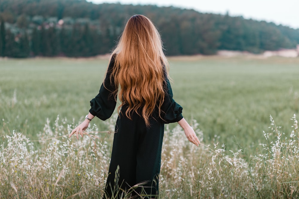 Woman in red tank top and black leggings standing on green grass field  during daytime photo – Free Skin Image on Unsplash