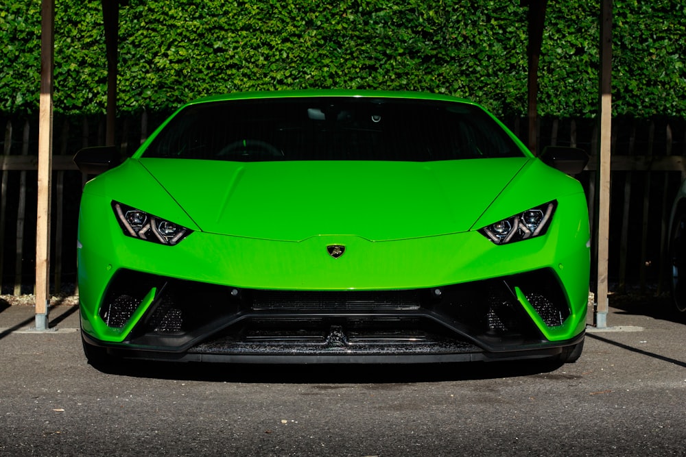 green Lamborghini Huracan sports coupe parked near wooden post
