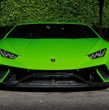 green Lamborghini Huracan sports coupe parked near wooden post