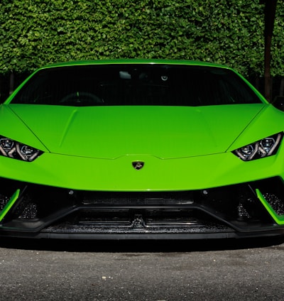 green Lamborghini Huracan sports coupe parked near wooden post