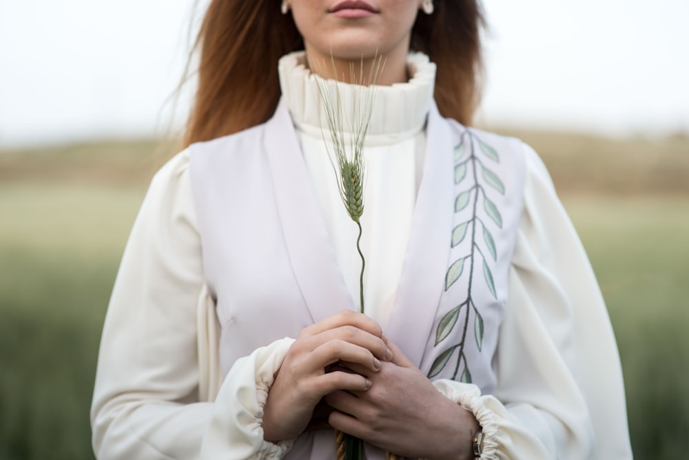 woman holding leafed plant