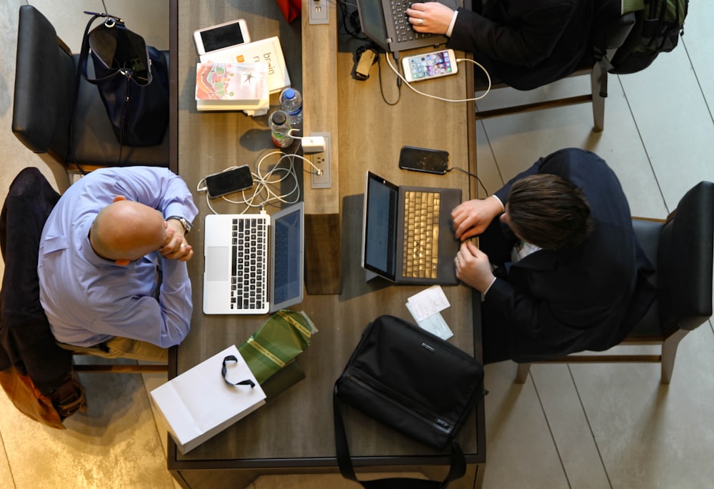 man sitting on chair in front of laptop and man