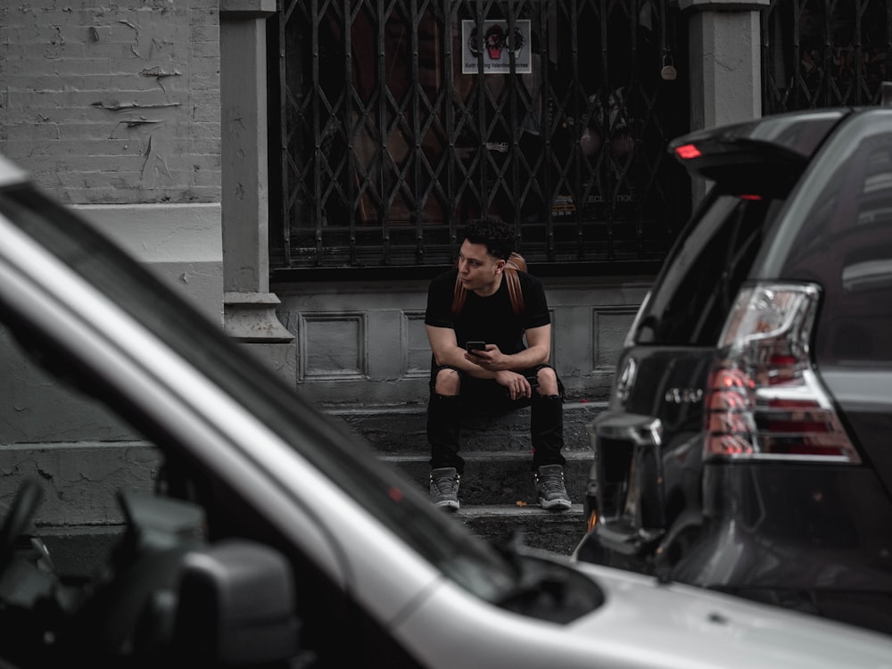 man sitting on black stairs