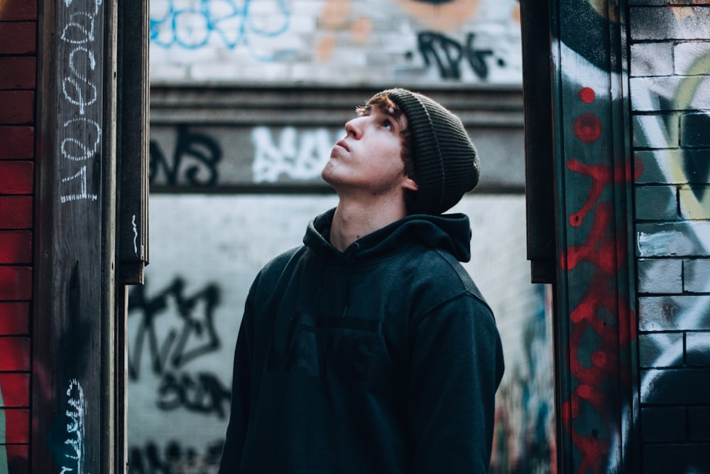 man wearing black hoodie looking up