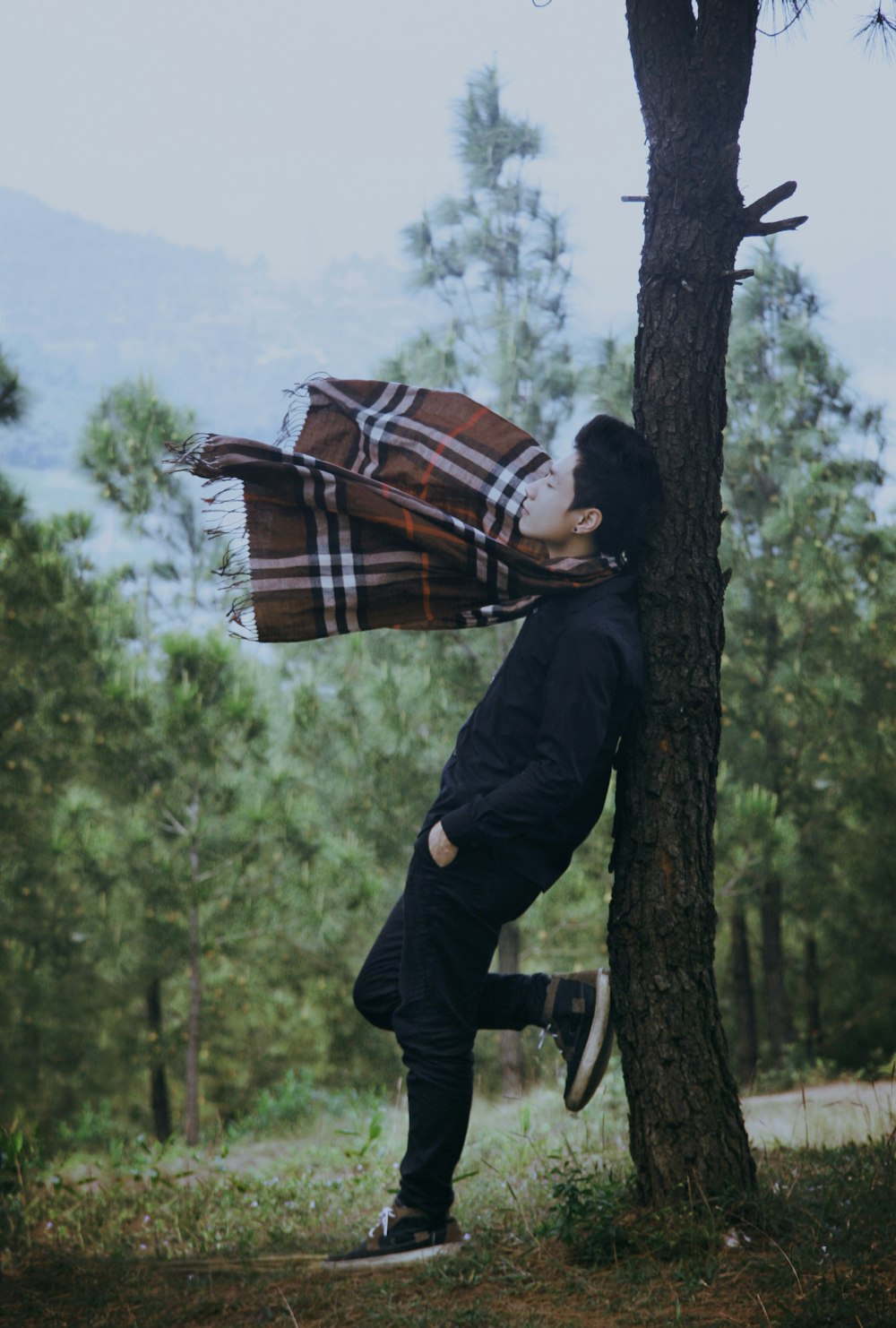 man standing beside tree