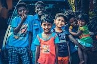 A happy family posing next to their recently purchased used car.