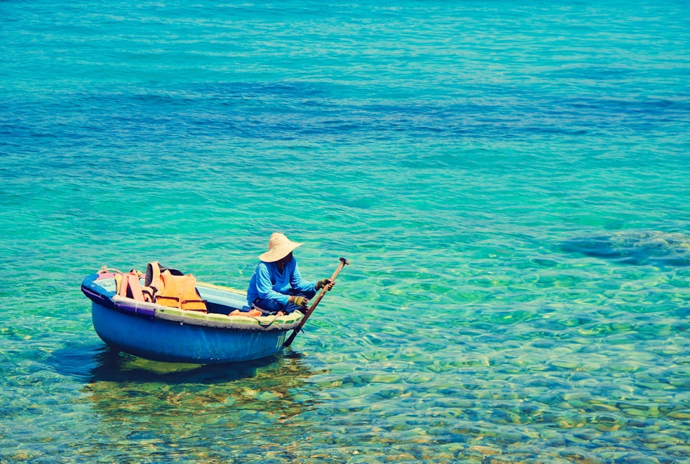 person riding blue boat on body of water