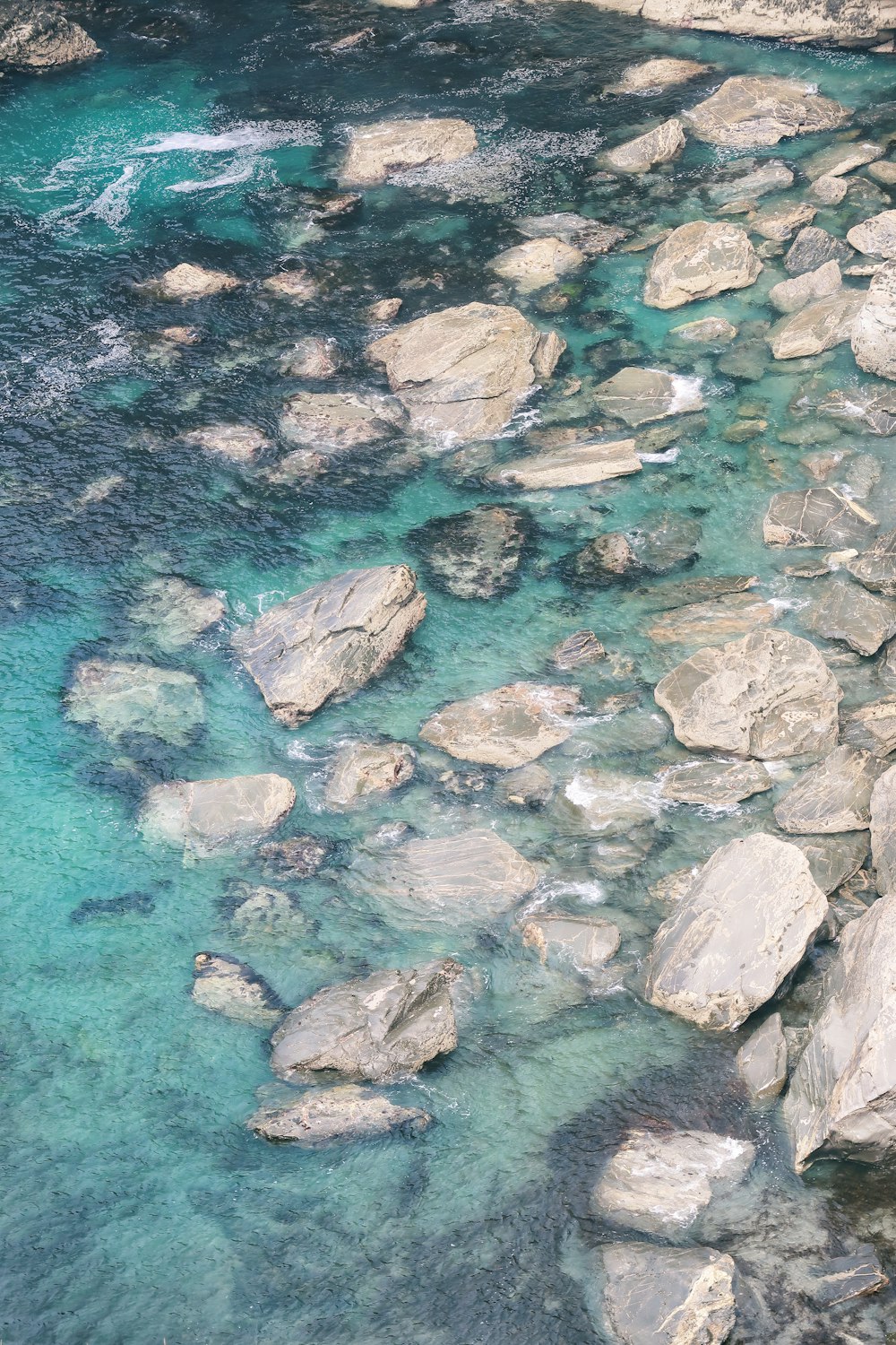 fotografia aerea di rocce grigie e specchio d'acqua durante il giorno