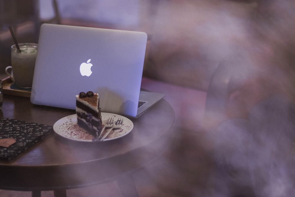 silver MacBook on top of brown table
