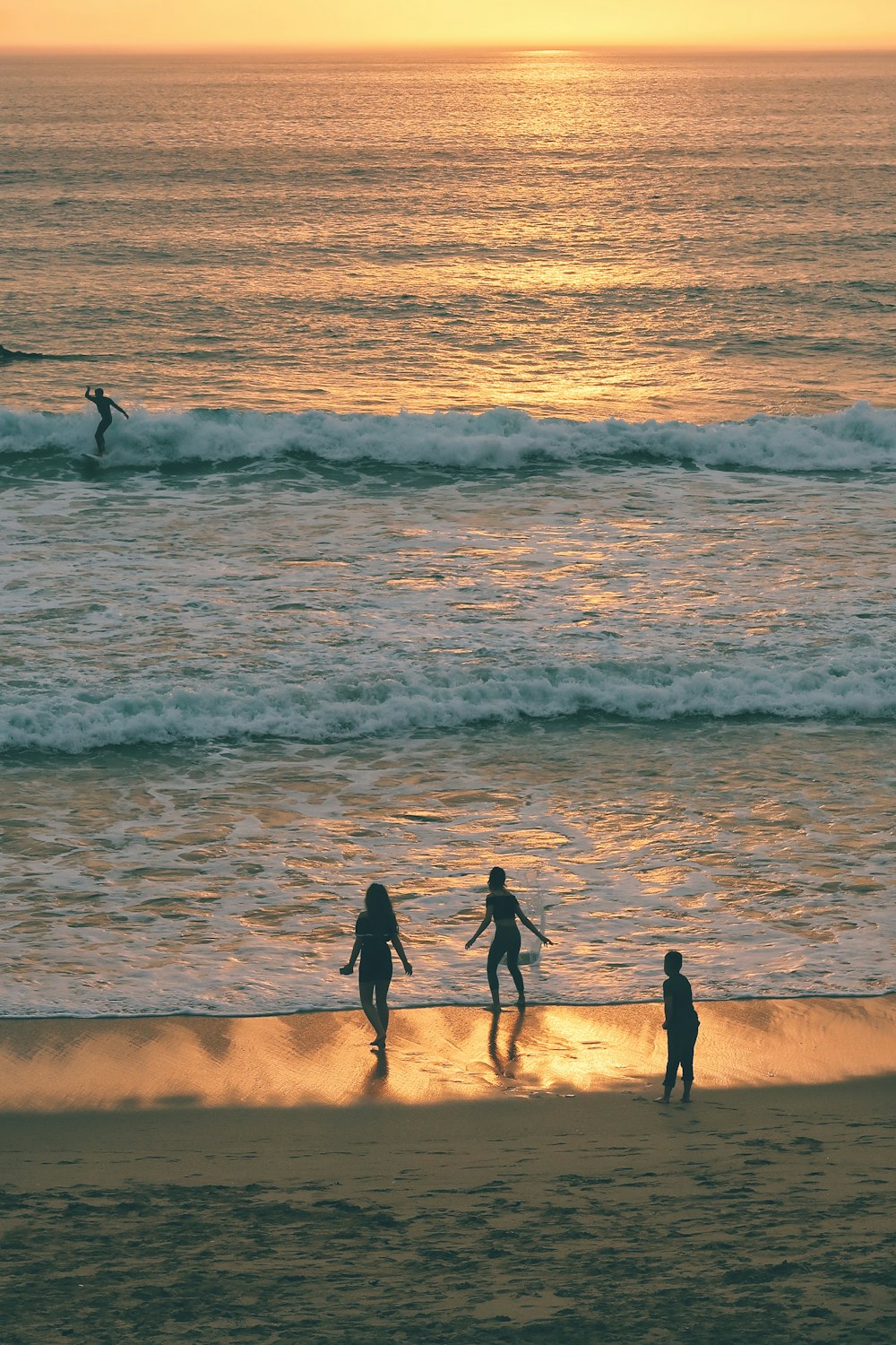 three person walking on sea shore