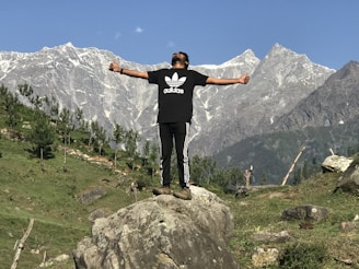 Instructor demonstrating CPR technique outdoors with mountain backdrop.