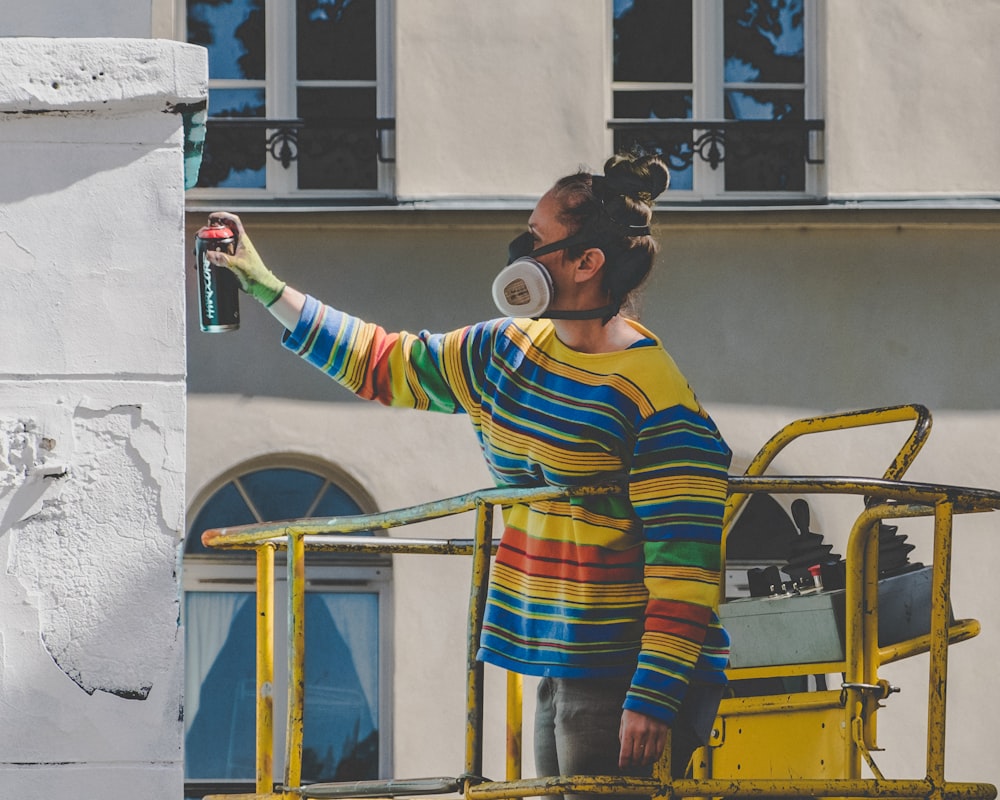 woman spraying paint during daytime