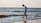 a man walking along a beach next to the ocean