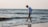 a man walking along a beach next to the ocean