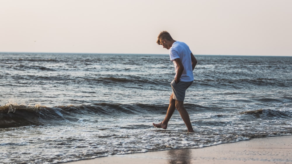 Un uomo che cammina lungo una spiaggia vicino all'oceano