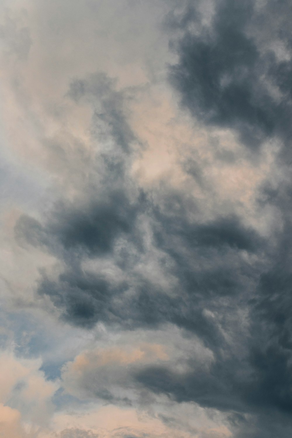 a plane flying through a cloudy sky on a cloudy day