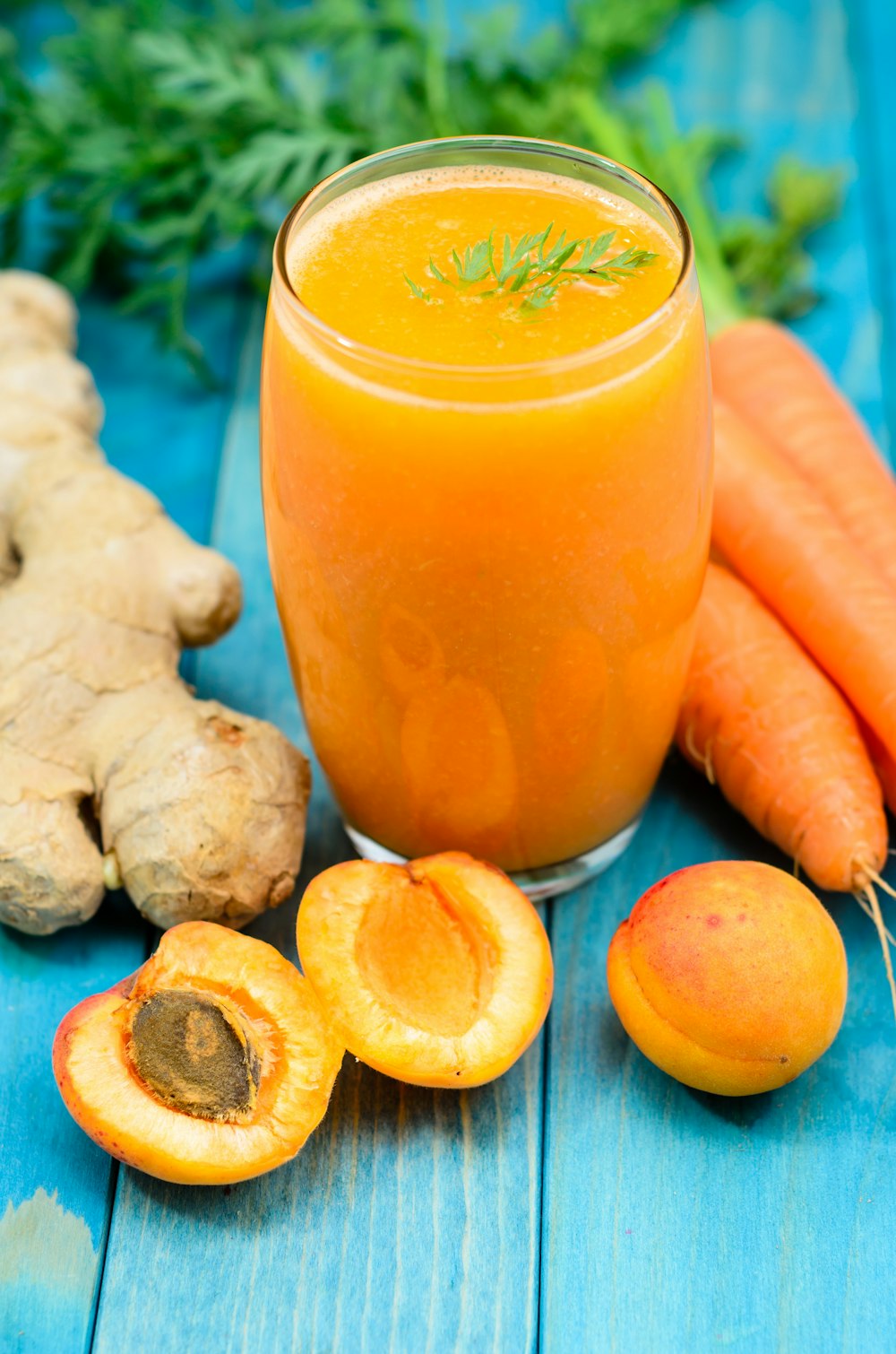 clear drinking glass besides carrots