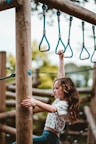 girl playing at monkey bar during daytime