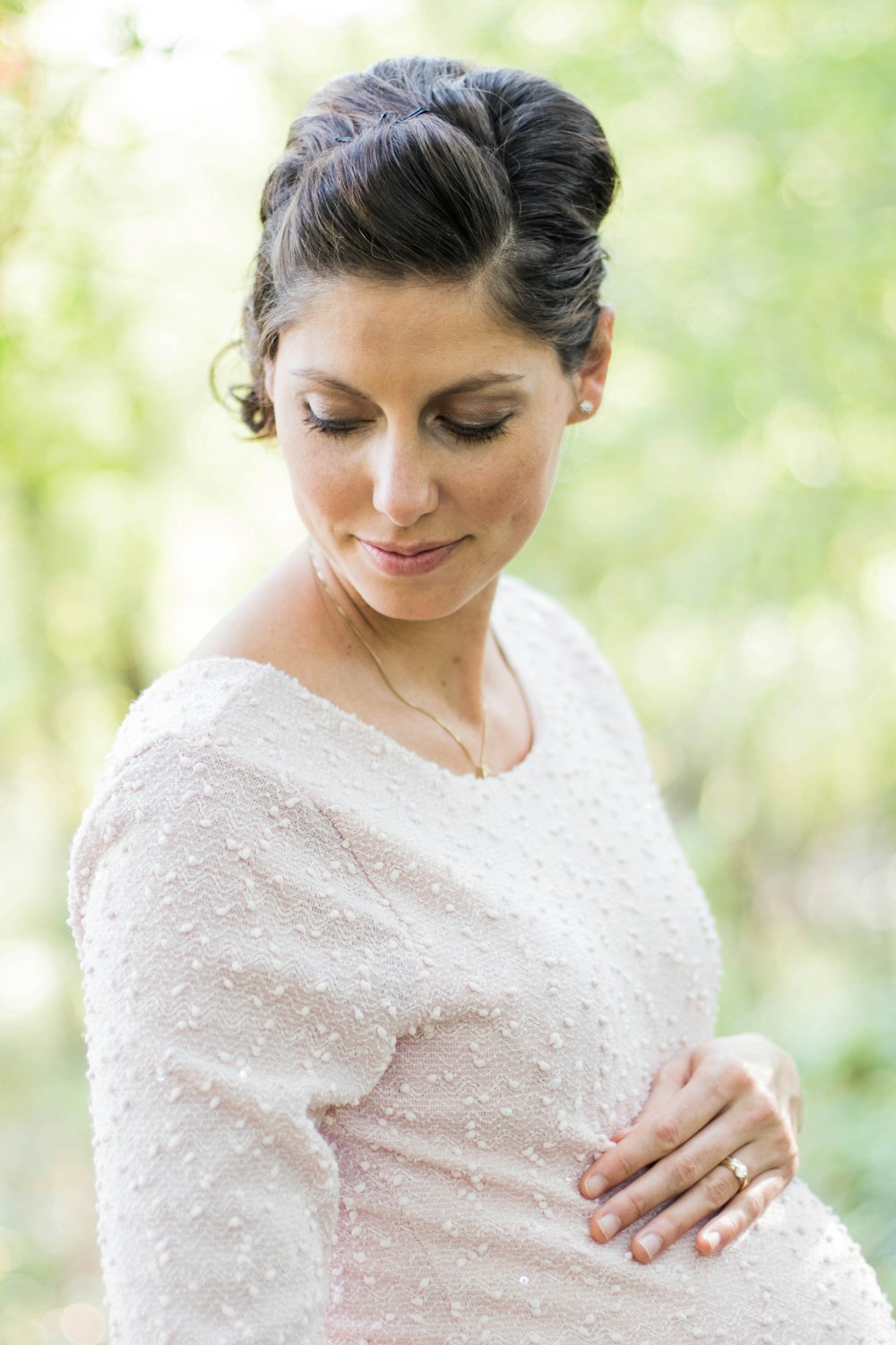 selective focus photography pregnant woman looking down white holding her tummy