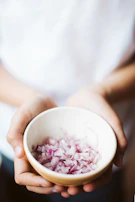 Hands arranging a vibrant salad, captured with a gentle cinematic glow.