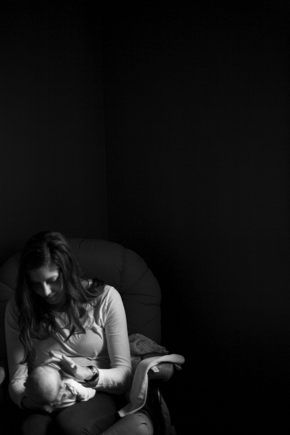 grayscale photo of woman holding a baby on her right hand while her left hand touching baby's face