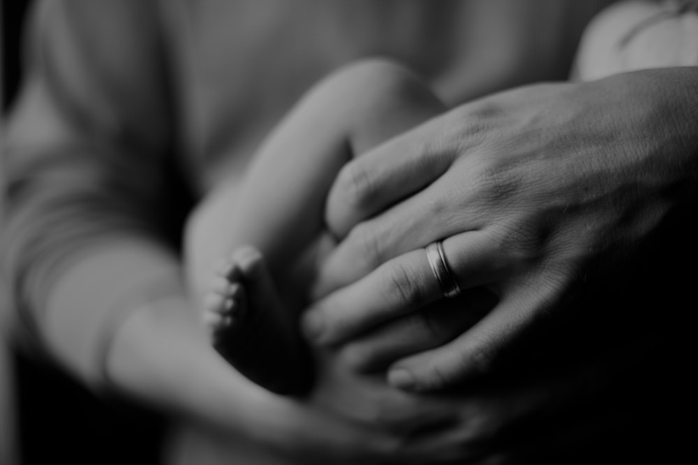 grayscale photo of person holding baby