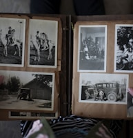 person opening photo album displaying grayscale photos