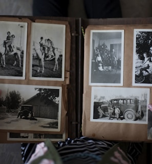 person opening photo album displaying grayscale photos